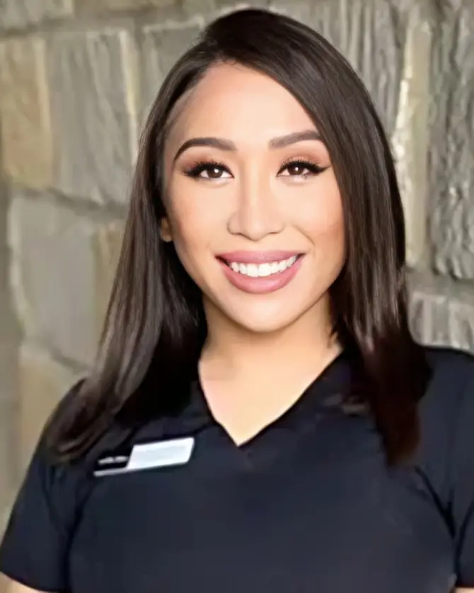 Smiling woman in black scrub top.