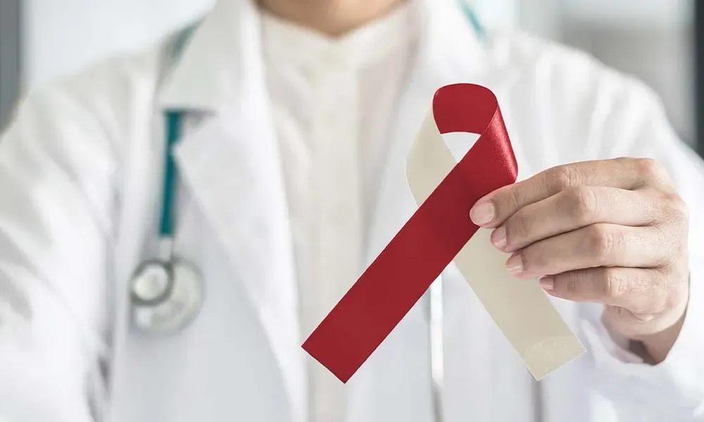 Doctor holding a red and white awareness ribbon.